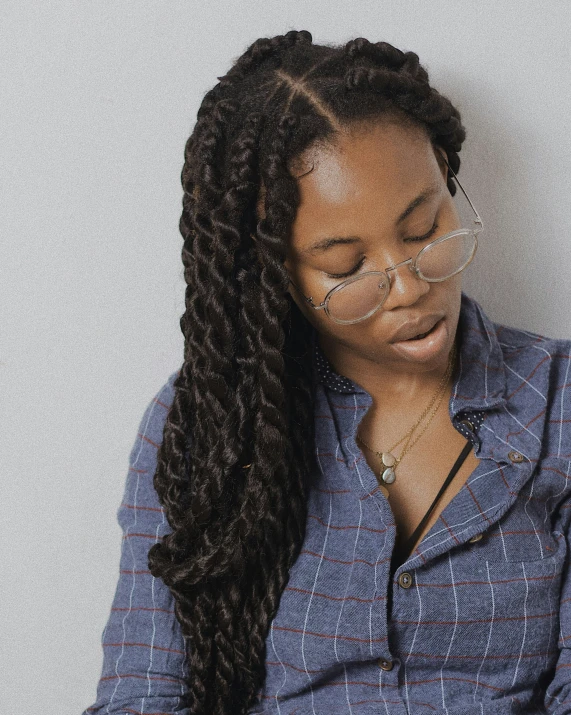 a woman wearing glasses leans over her face