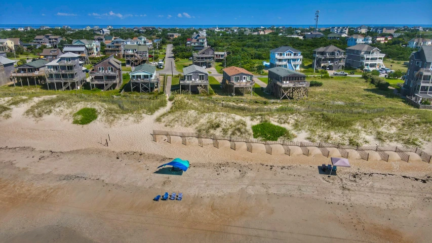 an aerial view of two lawn chairs on a sandy beach