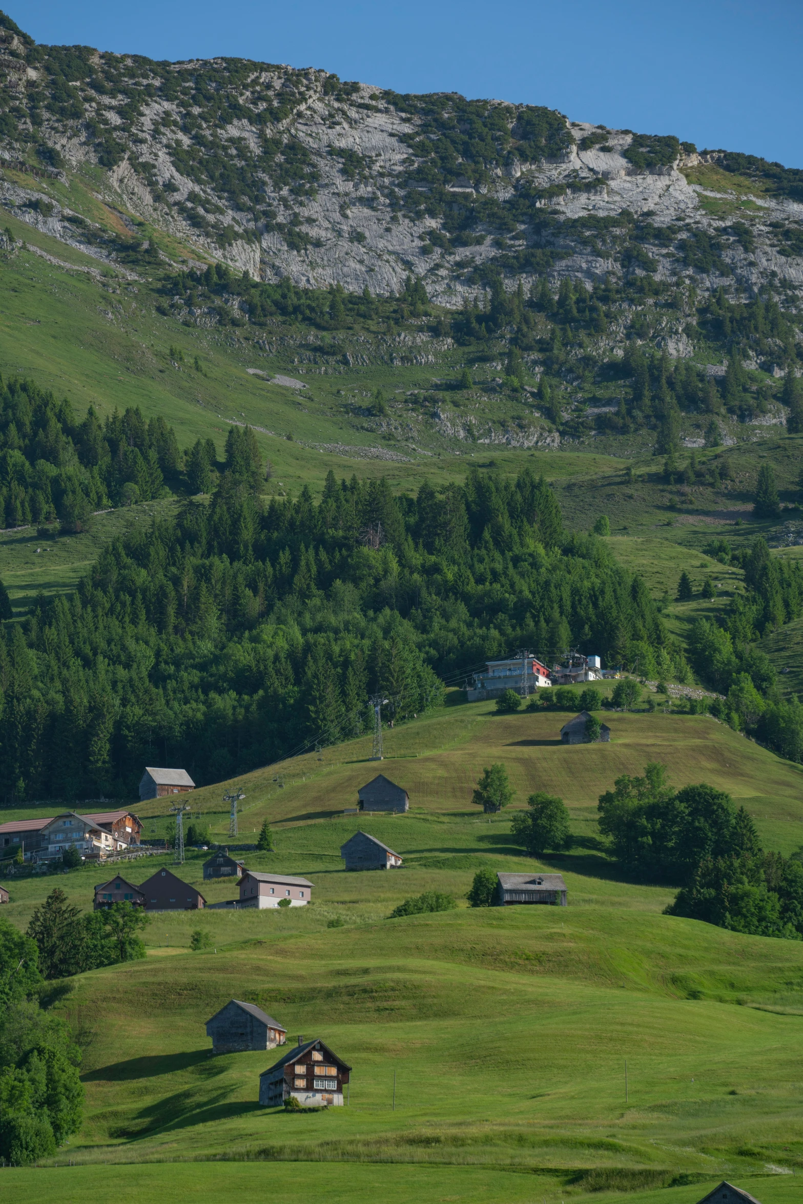 some houses on a hillside and hills with a blue sky