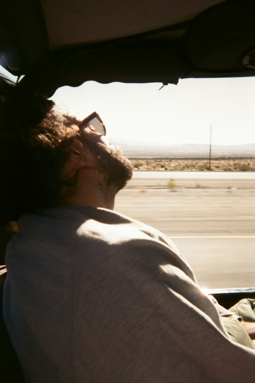 a man looking out a window as he sits in his car