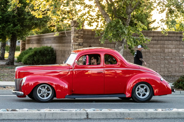 an old car that is parked in front of a brick wall