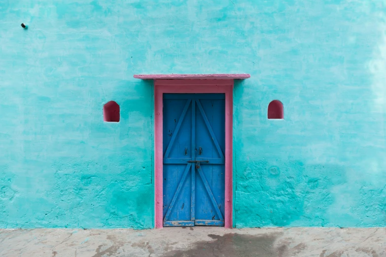 a blue door on a turquoise colored wall