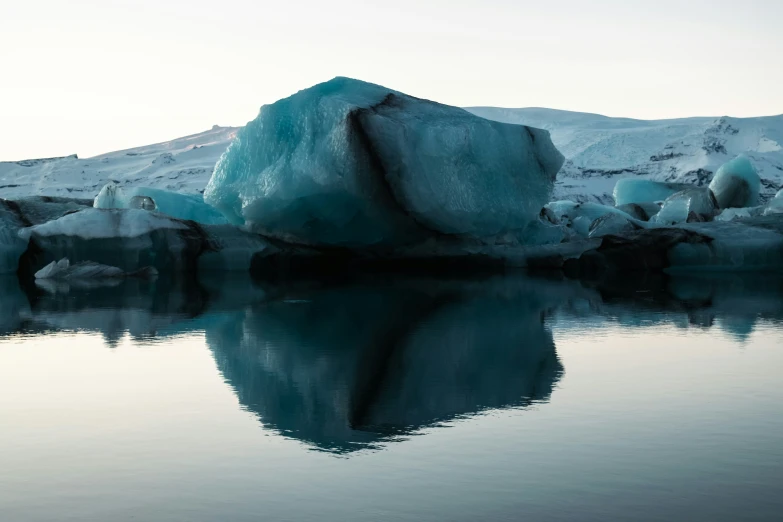 icebergs in the water near an icy mountain