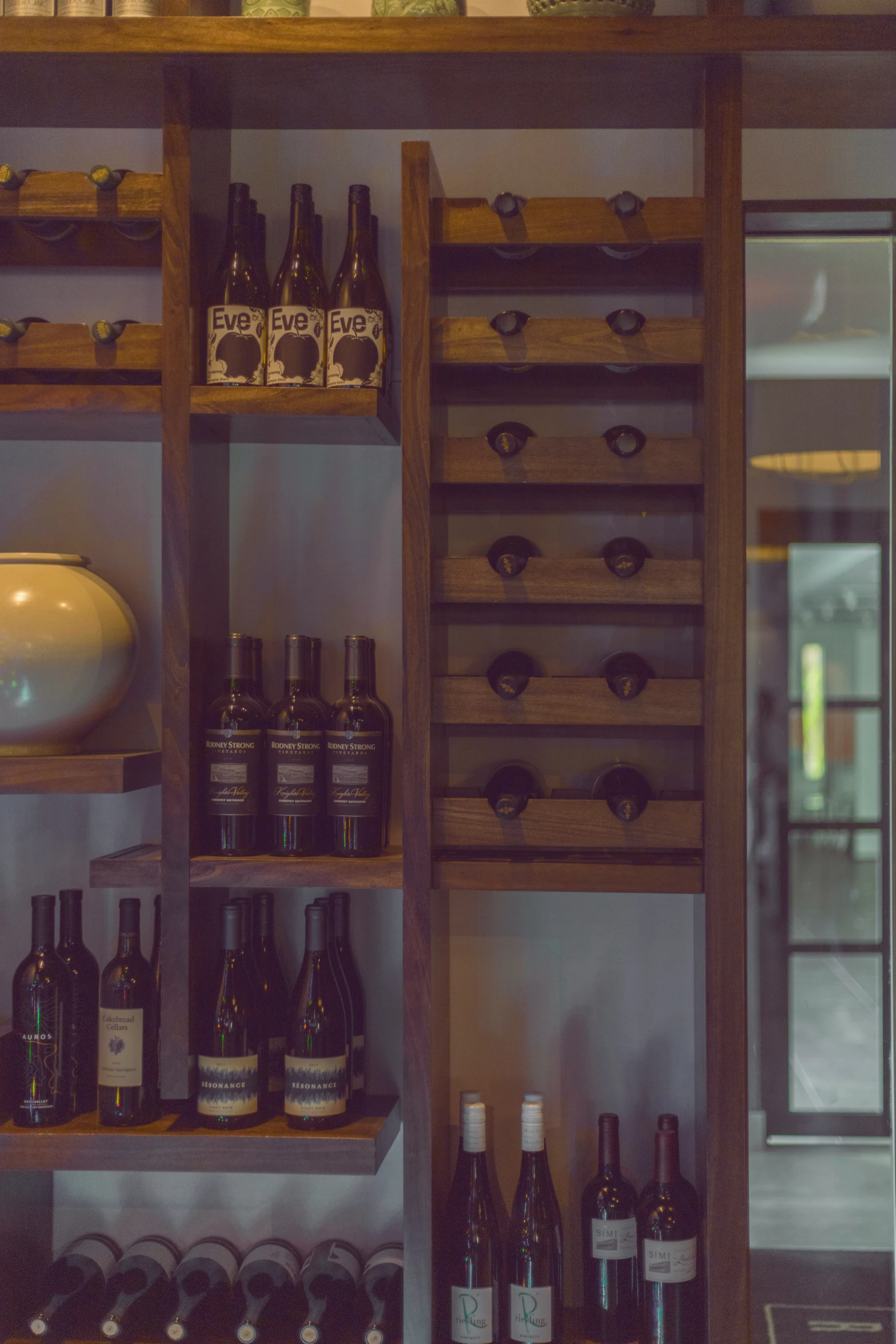 several shelves holding various wine bottles in different colors