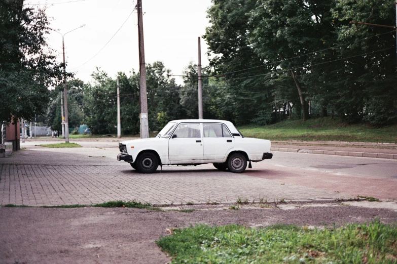 a white car is sitting in the middle of the street