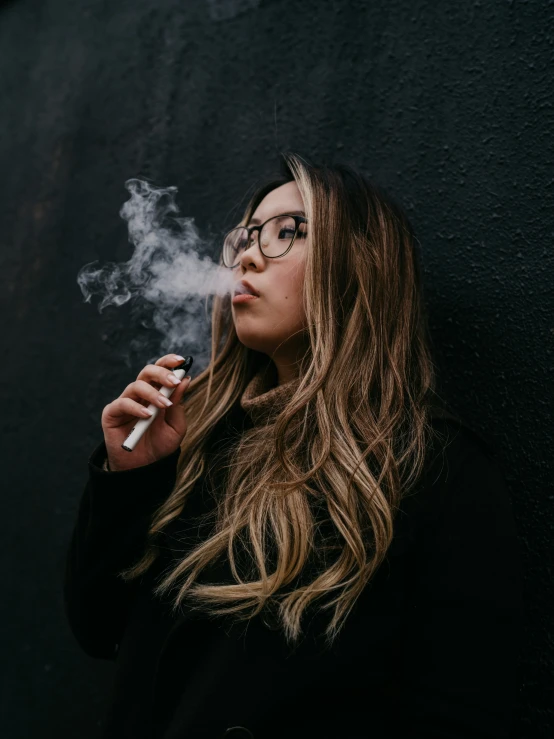 a woman smoking on her cigarette and looking at the camera