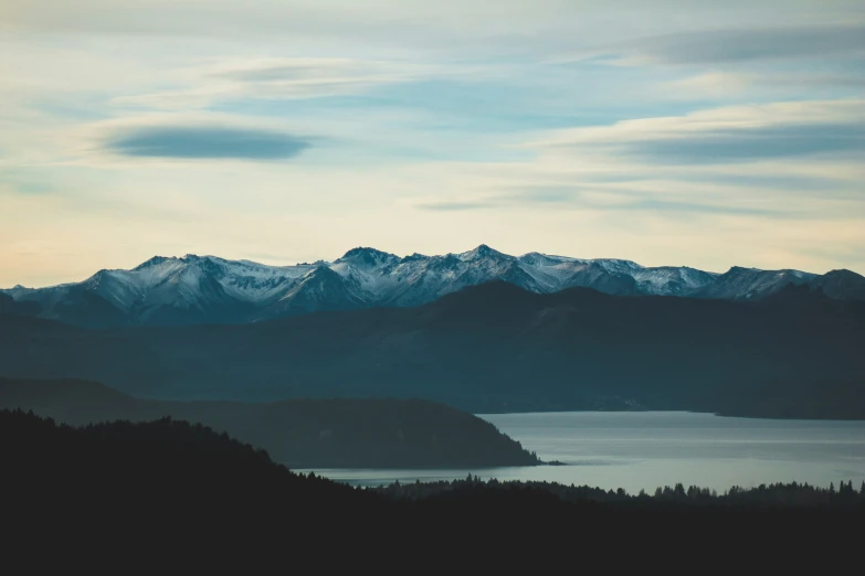 mountain range with water below and clouds above