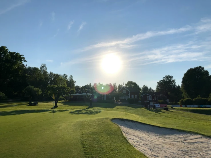 a golf course at the foot of some houses