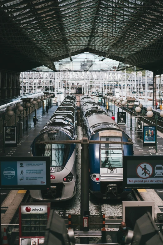 several trains that are on the tracks in a station