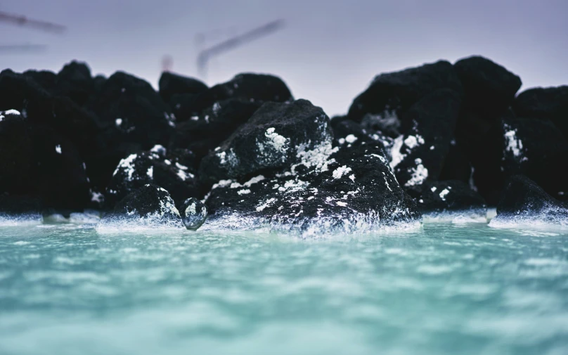 an ocean view shows rocks covered in white