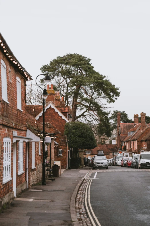 a quiet street that has cars parked on the sides