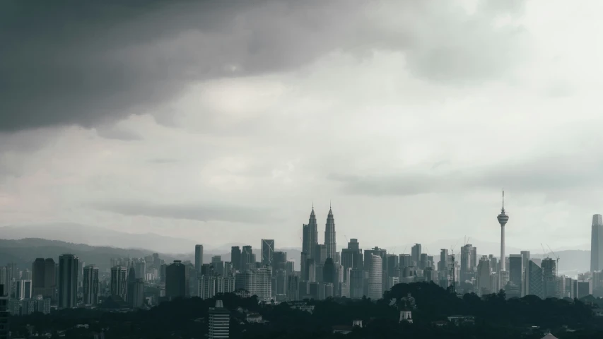 a city sits behind a large amount of dark clouds