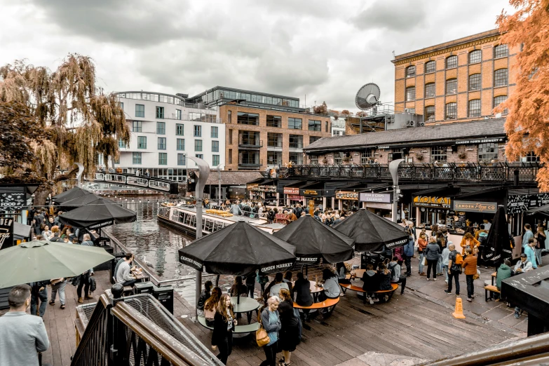 an outdoor market that has umbrellas over the tables