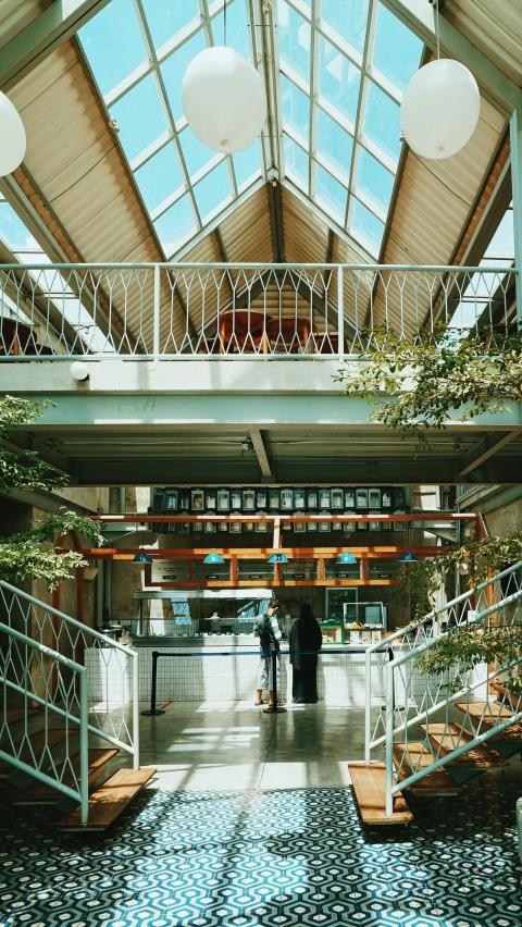 two white balloons and some plants inside a building