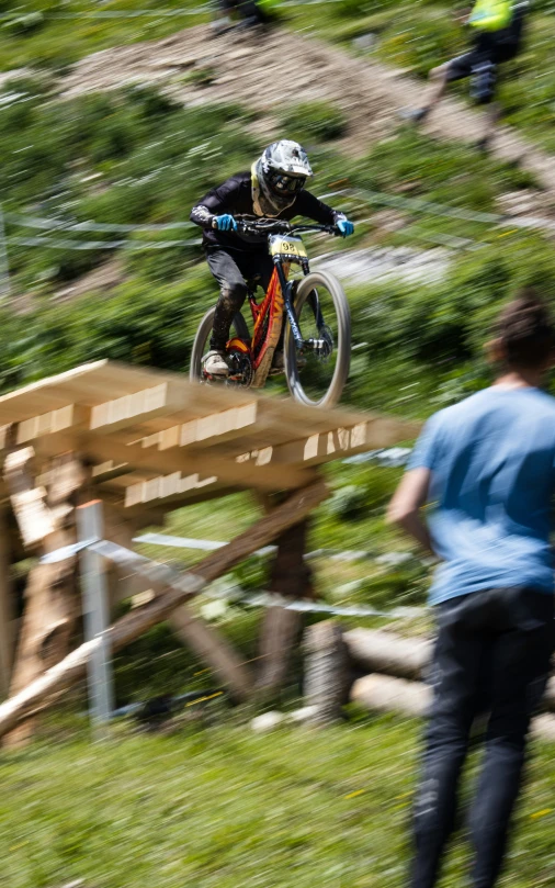 a man riding a bike down a wooden ramp