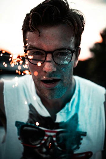 a man in glasses and a tie looks surprised by sparklers