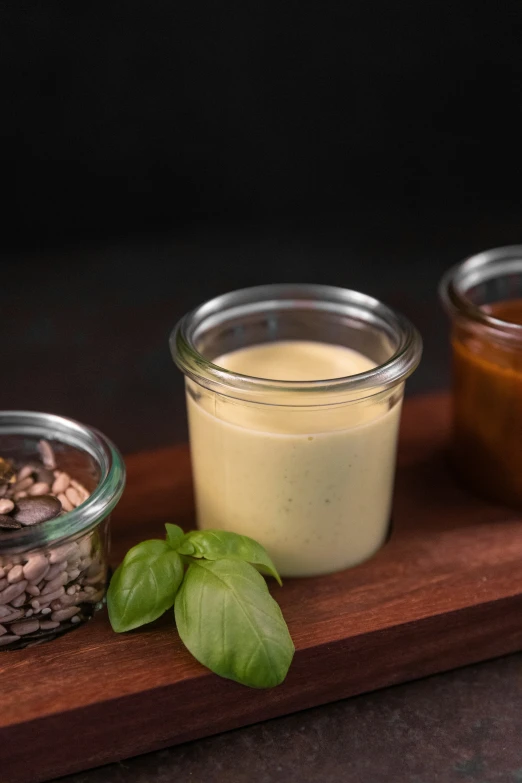 a wooden  board with jars of different types of food