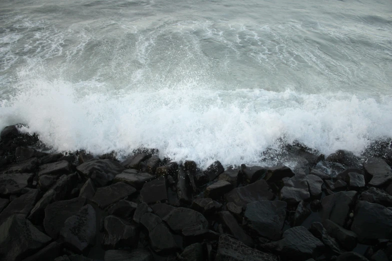 large waves crash into rocks on the beach