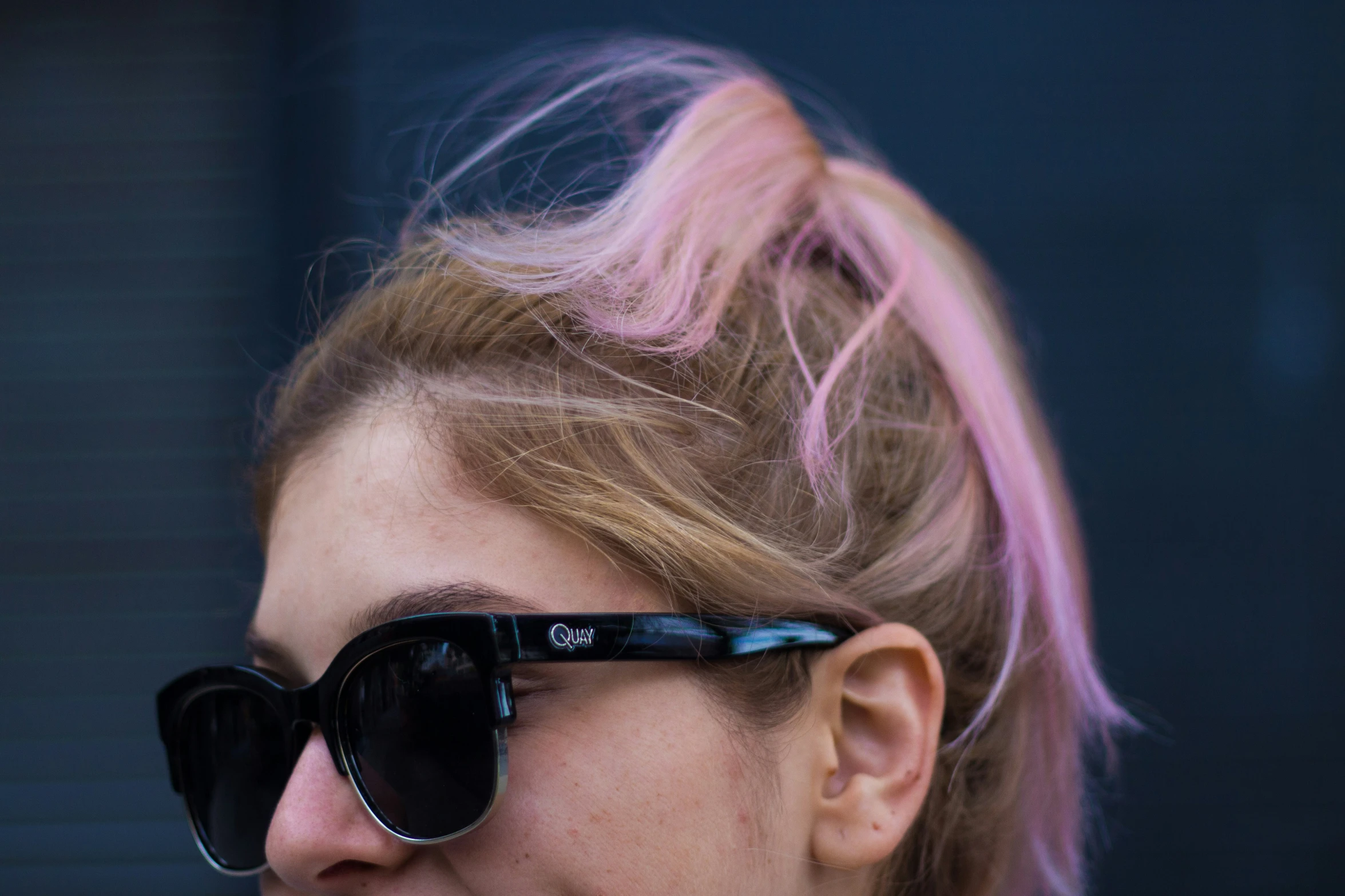 a blonde woman with black shades on her face