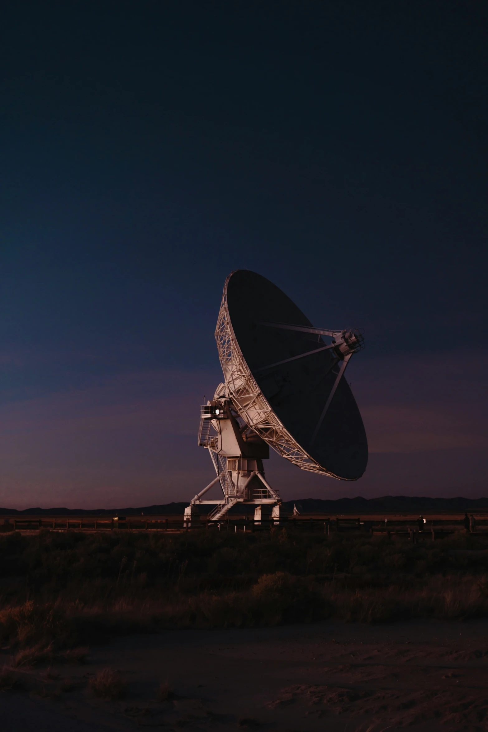 an older satellite dish is in the night sky