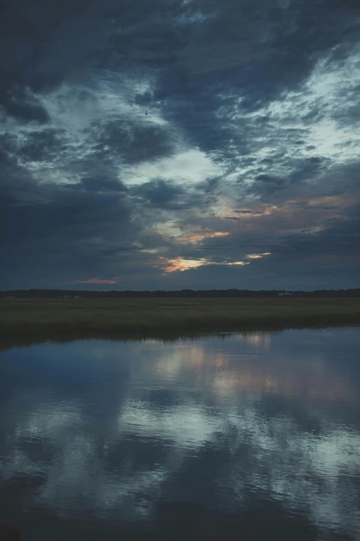 the sky above water and clouds with a distant horizon