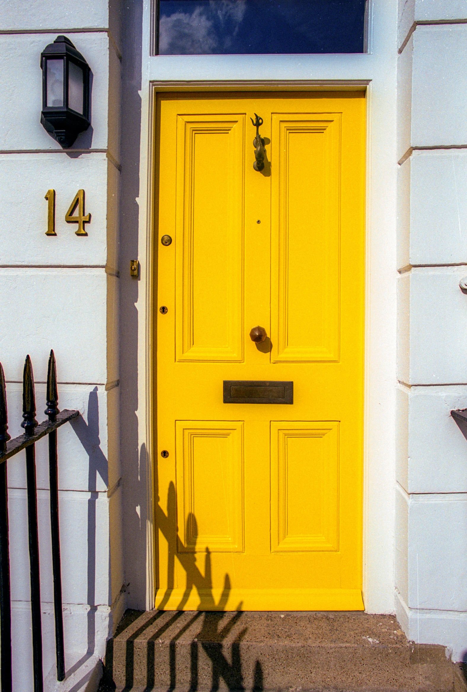 a large yellow door that is on a white house