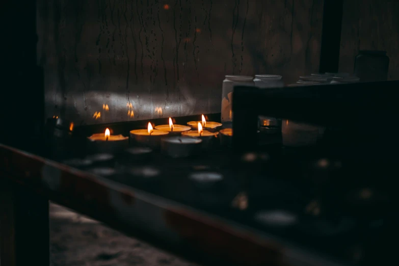 a group of candles that are sitting in the dark