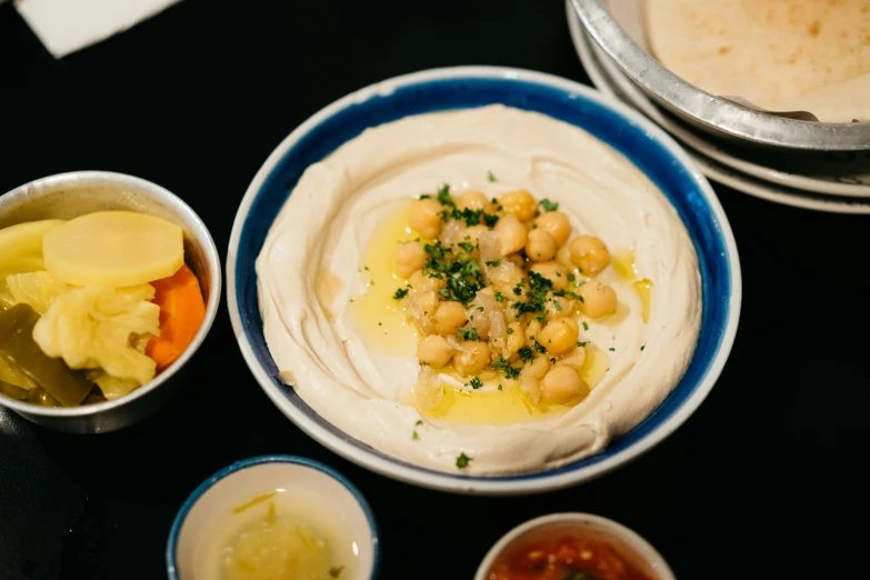 a couple of bowls filled with white hummus