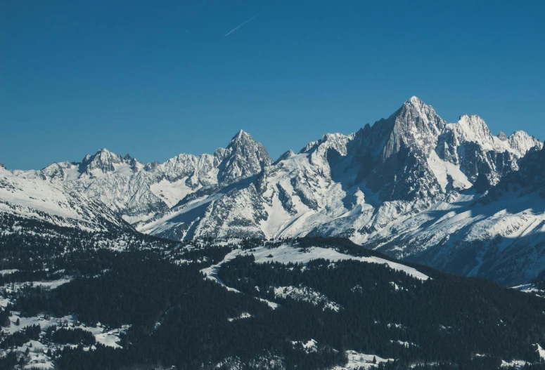 the view from top of a mountain of snow covered mountains