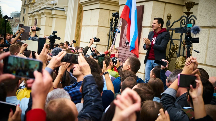 a man holding a smart phone and taking pos