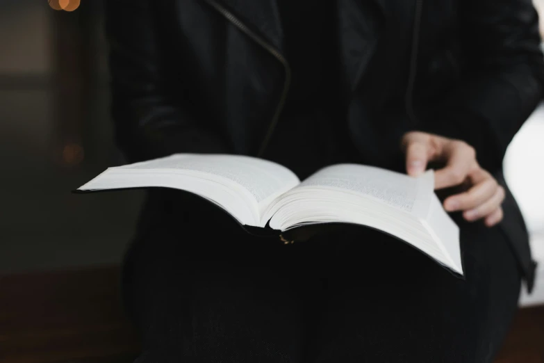 a person that is sitting down with an open book