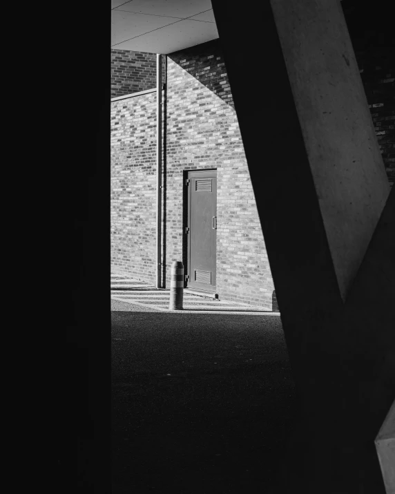 black and white po of a door open on a brick wall