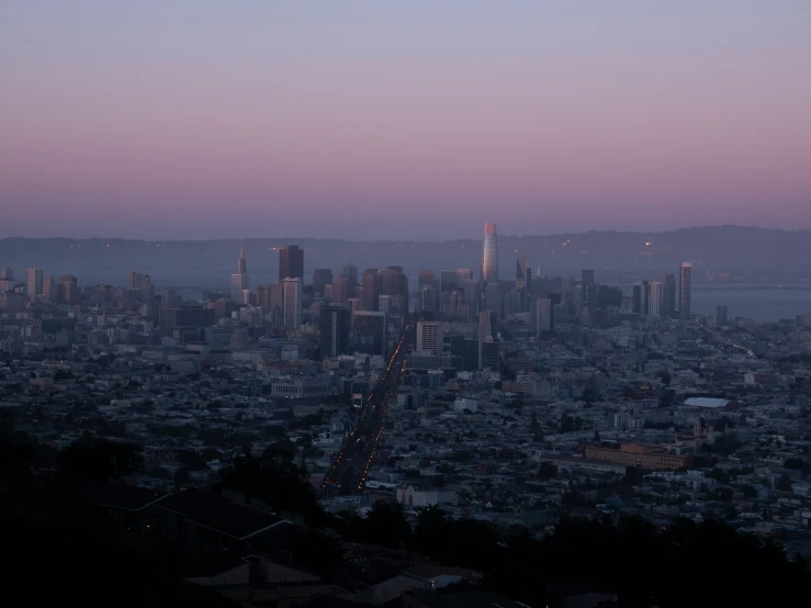 city lights shining over the skyline at twilight