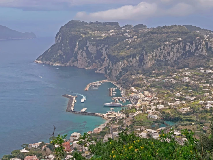 a scenic view of the city on a hillside near an ocean