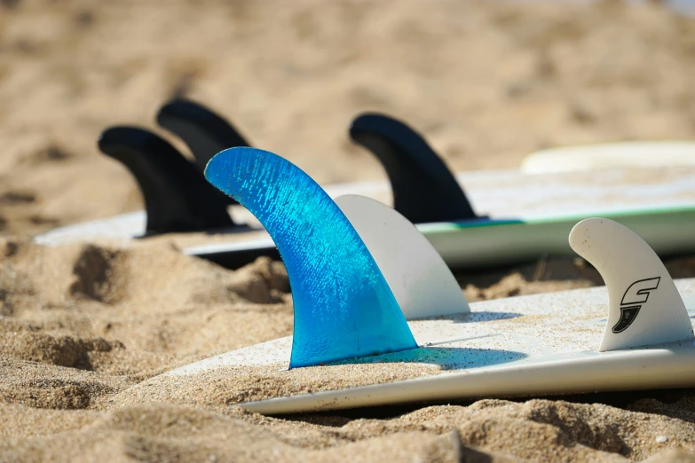 some surf boards that are laying in the sand