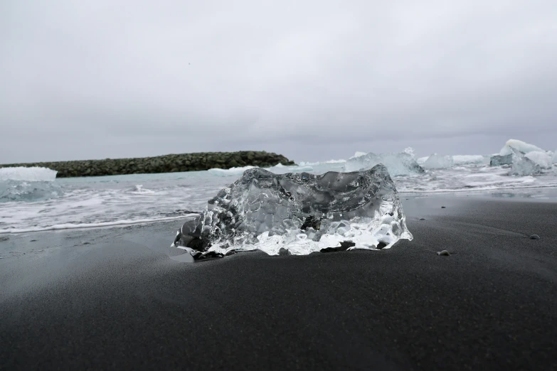 an iceberg on the beach with another in the background