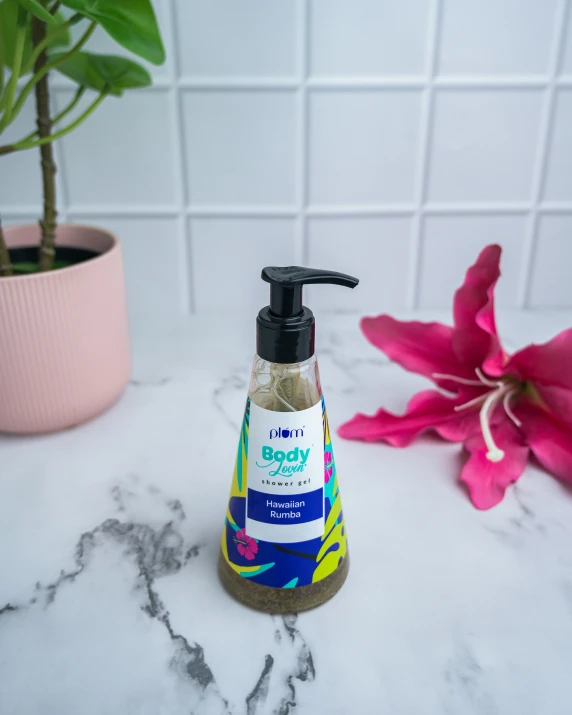 a hand soap bottle sitting on a counter near flowers