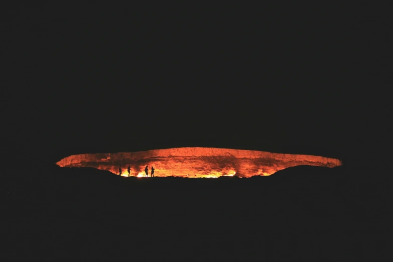 a group of people standing on top of a hillside at night