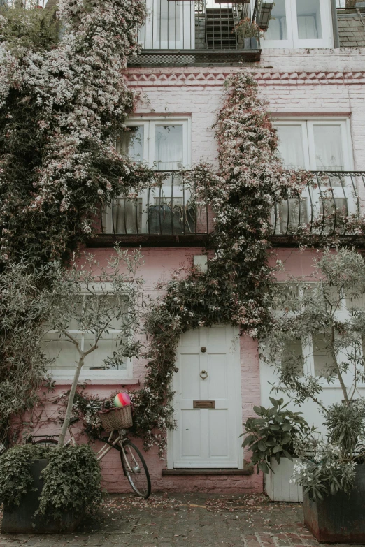 an apartment building has pink stucco and white doors