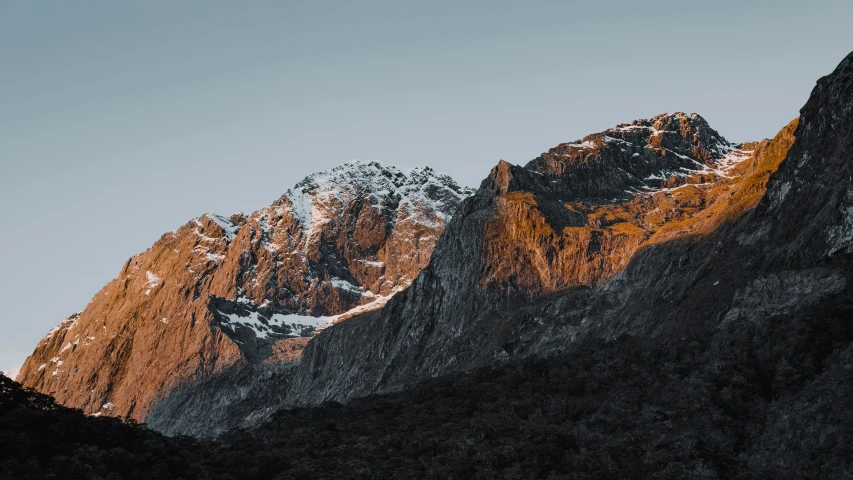 a mountain and sky seen against the bright light of a sunrise