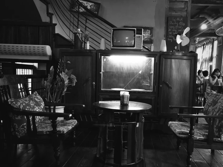 two people and a tv sitting inside of a living room