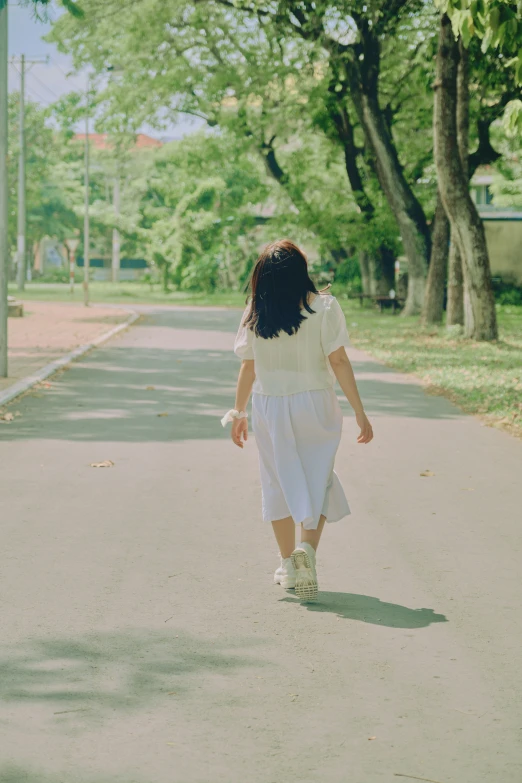 a person walking down the road holding their hand and looking back