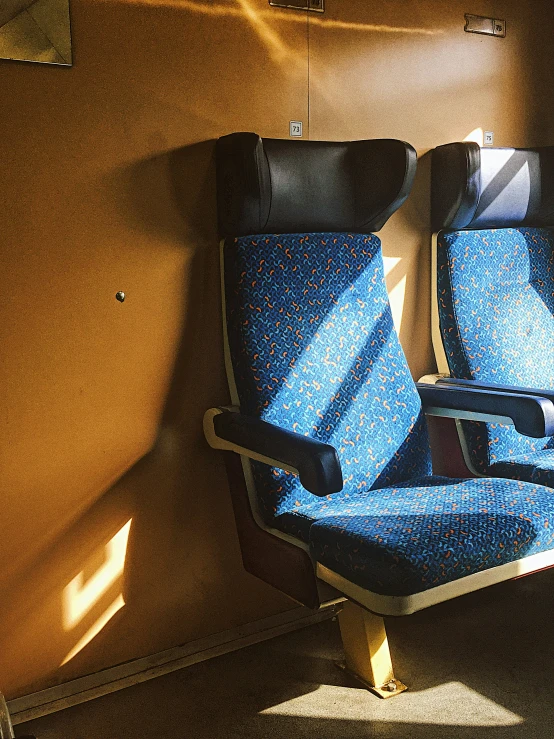 two seats in the sunlight against a wall