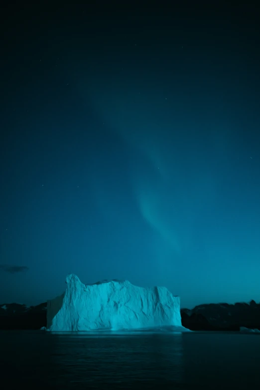 an iceberg in a dark blue ocean