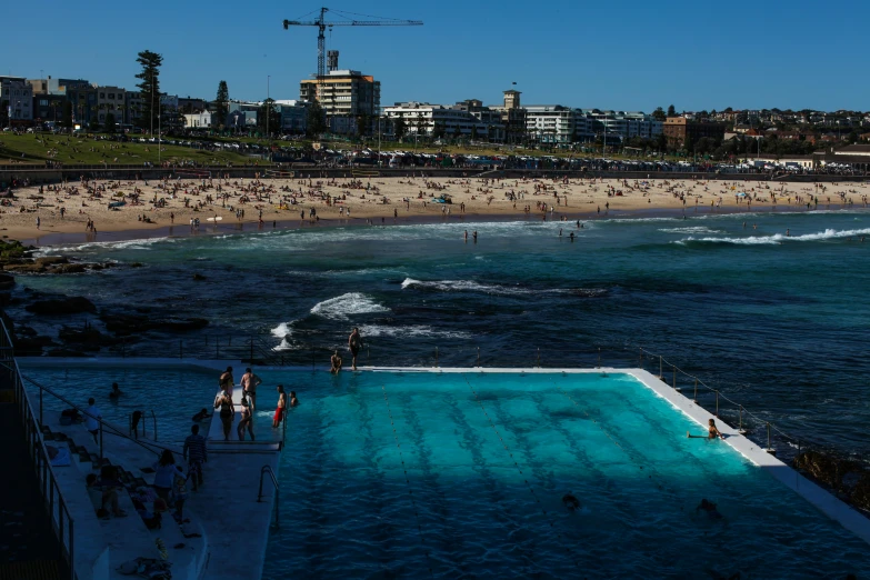 some people are swimming in the blue water of the beach