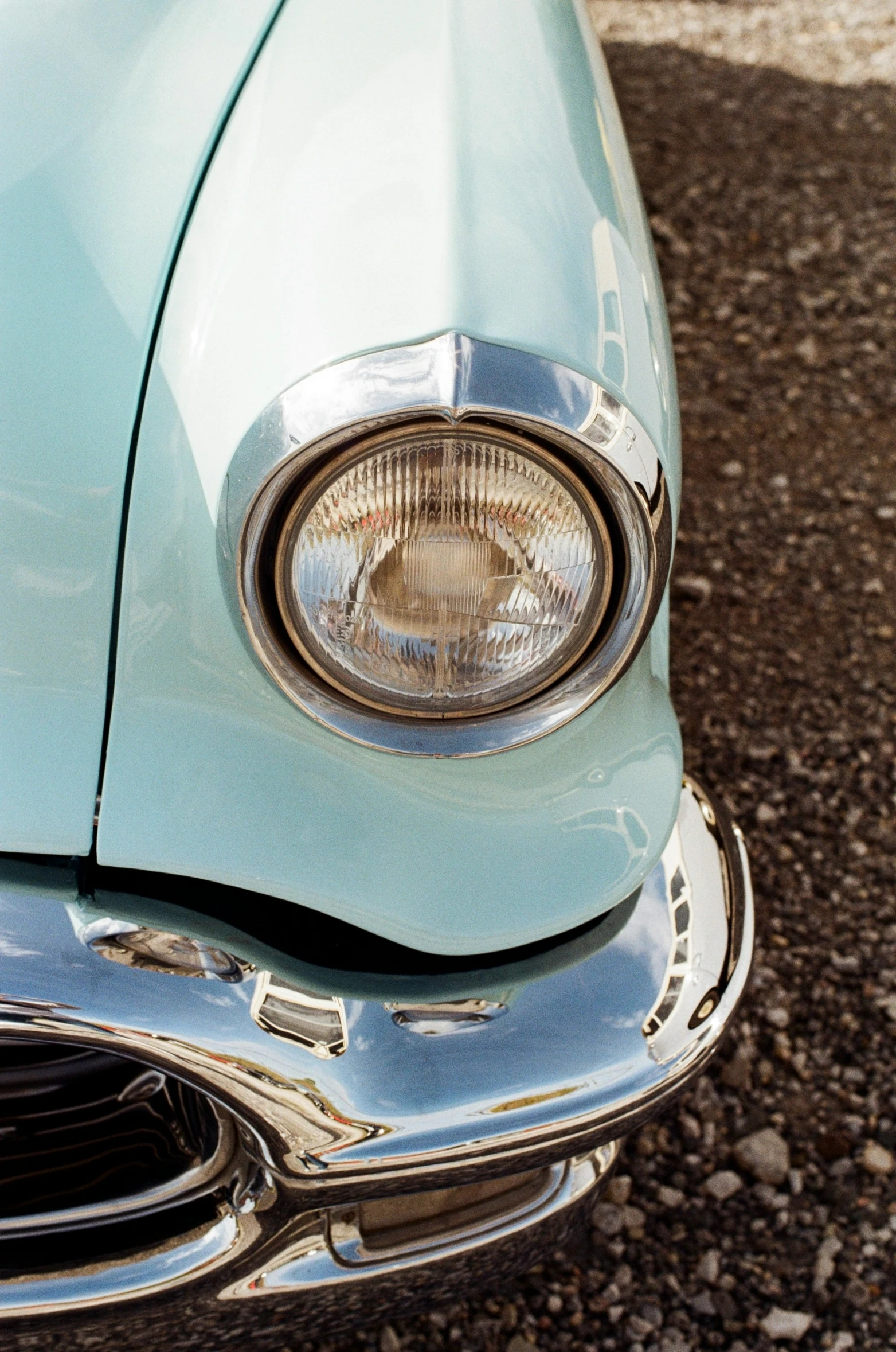 a close up of the headlight on an old blue car