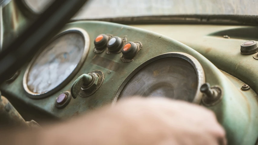 the dashboard of an old green car with ons on it