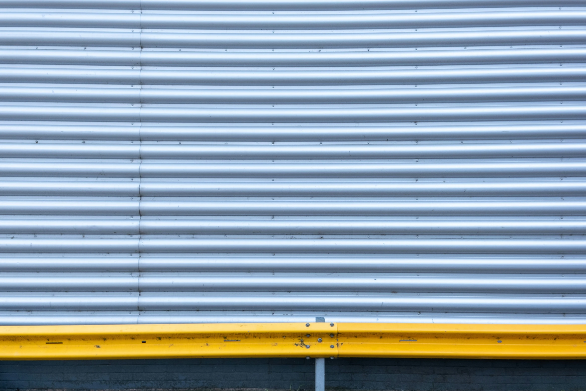 yellow and grey metal slats against a blue wall