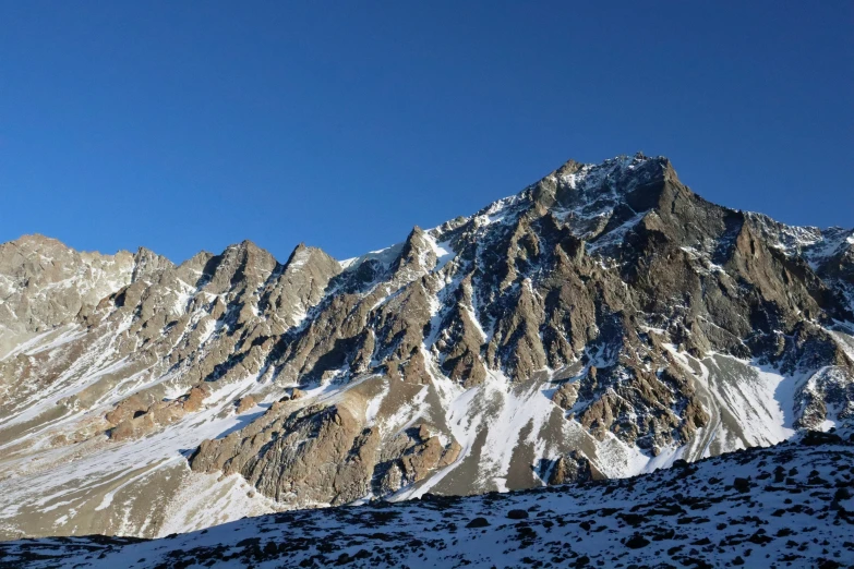 the sun shining on snow capped mountains below