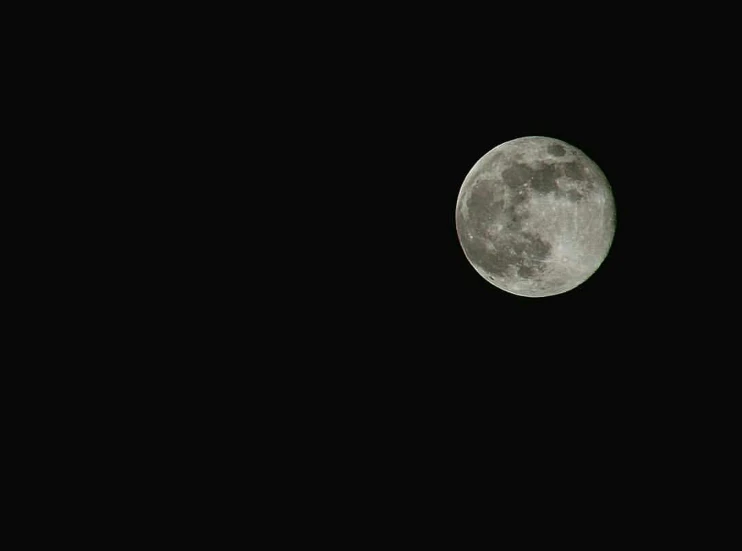 the full moon shining in the dark sky